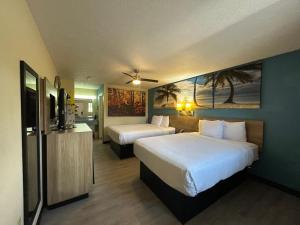 a hotel room with two beds and a television at Deerfield Inn in Parsons