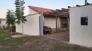 a white building with a small tree next to it at Rancho Petite Fleur in Aparecida do Taboado