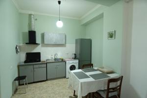 a kitchen with a table and a sink and a refrigerator at Peaceful Tbilisi Apartment Wifi in Tbilisi City