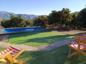 a yard with two chairs and a swimming pool at Casa Mamalluca in Vicuña