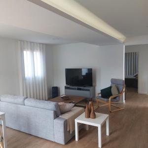 ein Wohnzimmer mit Sofa und Fernseher in der Unterkunft Paradise Point Sea & Mountain view in Estreito da Calheta