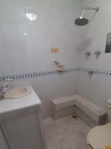 a white bathroom with a sink and a toilet at Castillo de Mario in Cancún
