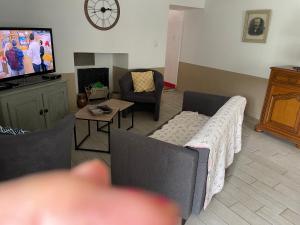 a living room with a couch and a tv at ST JEAn in Baume-les-Messieurs