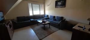 a living room with a couch and a table at Avec piscine 06-17-61-38-73 in Ifrane