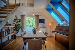 a dining room with a table and a piano at Attic apartment & terrace in Graz