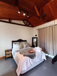 Un dormitorio con una cama grande en una habitación con techos de madera. en Oriebruggie Accommodation, en Calvinia 116 fotos más