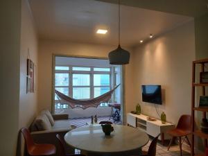 a living room with a table and a large window at Historico Edf Oceania in Boa Viagem in Recife