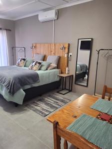 a bedroom with a bed and a mirror and a table at 3de laan Springbok in Springbok