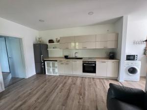 a kitchen with white cabinets and a black refrigerator at Feld & Flair Apartment in Lage