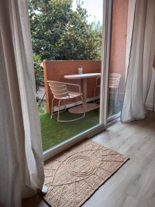 a view of a table and chairs outside a window at Appartement Cosy Bord de mer in Le Pradet