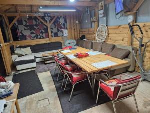 a living room with a wooden table and chairs at Sobe Kovacevic in Cvijetići