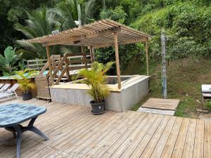 a wooden deck with a hot tub and a pergola at Sweet Mangot in Gros-Morne