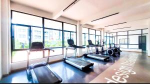 a gym with several treadmills and large windows at Urban Stays-Two bedroom Near JKIA Airport in Nairobi
