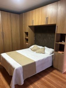 ein Schlafzimmer mit einem großen Bett mit Holzschränken in der Unterkunft Chalé cipreste 3 Quartos in Gramado + 45 Fotos