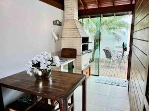 a kitchen with a table with a vase of flowers on it at 250m do Mar com Hidromassagem, Chale aconchegante para relaxar in Governador Celso Ramos