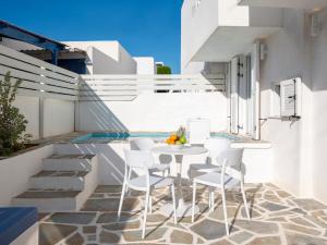 a patio with a white table and white chairs at Casa De Tamara Paros in Kampos Paros