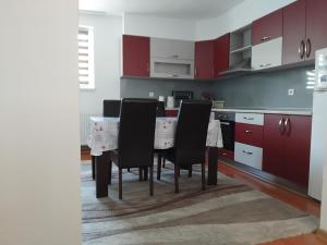 una cocina con armarios rojos y una mesa con sillas. en Dinn, en Jajce