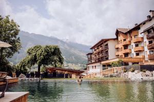 a man standing in the water in a pool of water at SPA & Naturhotel Outside in Matrei in Osttirol