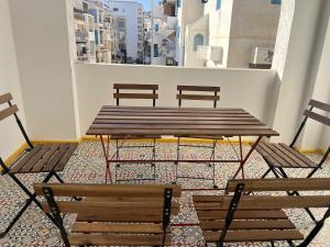 three benches and a table and chairs in a room at Martil Concept in Martil