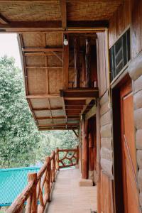 a wooden porch of a house with a wooden ceiling at Bukit Lawang - Batu Kapal Rimba House in Bukit Lawang