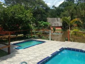 a swimming pool in the middle of a yard at Sítio Isolina Piscina, Campo e Lago in Juquitiba