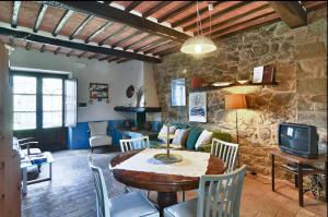 ein Wohnzimmer mit Tisch und Fernseher in der Unterkunft AGRITURISMO Casale Il Caggio in Ciggiano