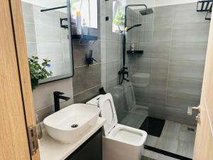 a bathroom with a white sink and a toilet at Urban Stays-Two bedroom Near JKIA Airport in Nairobi +9 photos