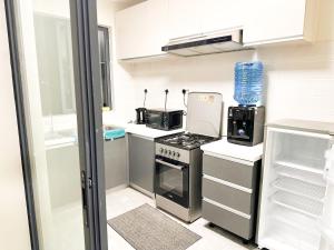 a small kitchen with a stove and a refrigerator at Urban Stays-Two bedroom Near JKIA Airport in Nairobi