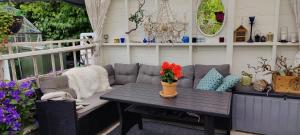 a patio with a couch and a table with flowers on it at Øya husrom-enkeltsenger-kjøkken-bad in Sarpsborg