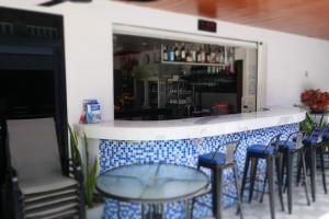 a bar with blue chairs and a glass table at Treff nad phop hotel in Patong Beach