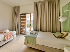 Un dormitorio con dos camas y una gran ventana. en Salgados Premium Beach Villa 4 Suites, en Guia 42 fotos más