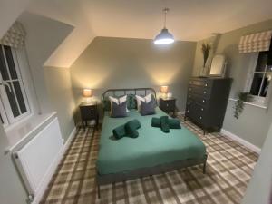 a bedroom with a green bed with two pillows at Neptune House The Bay Filey Home Sweet Holiday Homes with car ev point in Filey