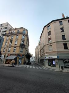 an empty city street with two tall buildings at 'La forêt enchantée' in Villeurbanne