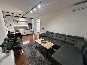 een woonkamer met een bank en een tafel bij Apartman Spring Premium with Garage in Sarajevo