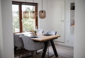 a dining room table with chairs and two chandeliers at Panorama-Seeblick, Privater Steg, Balkon, Parkplatz in Plön