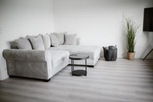 a living room with a white couch and a table at Panorama-Seeblick, Privater Steg, Balkon, Parkplatz in Plön