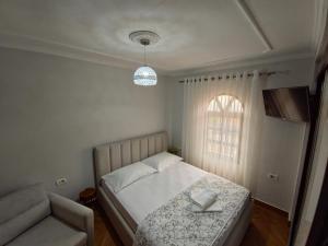 a bedroom with a bed and a chair and a window at Guri Imperium in Krujë
