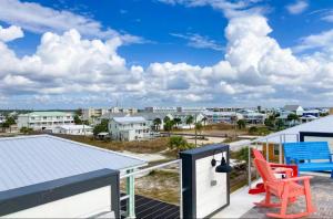 a view from the balcony of a house with a red chair at Happy Ours in Mexico Beach
