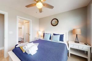 a bedroom with a blue bed with a ceiling fan at Happy Ours in Mexico Beach