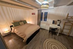 a bedroom with a large bed and a desk at Maison typique 3 chambres entre vignes et montagnes - SPA - Route des vins proche Eguisheim in Obermorschwihr