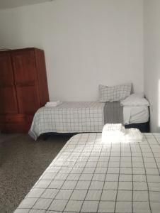 a bedroom with two beds and a dresser at HTA Hospedaje Turismo Aventura in San Fernando del Valle de Catamarca