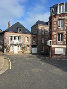 an empty street in front of two brick buildings at Veules-les-Roses Studio in Veules-les-Roses +13 photos