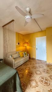 ein Wohnzimmer mit einer Couch und einem Deckenventilator in der Unterkunft Vista Mar - Kitnet Espaçosa - Tupi in Praia Grande