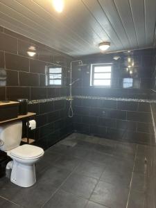 ein Bad mit WC und blau gefliesten Wänden in der Unterkunft Studio RIO in Roche Cabrit