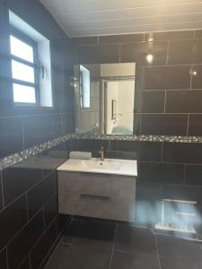 ein Badezimmer mit Waschbecken und Spiegel in der Unterkunft Studio RIO in Roche Cabrit