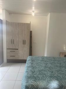 ein Schlafzimmer mit einem Bett und einem Schrank in der Unterkunft Studio RIO in Roche Cabrit