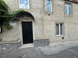 a building with a black door on the side of it at Borjomi Cozy Cottage in Borjomi
