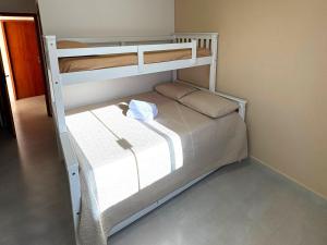 una camera con un letto a castello bianco di Oasis das Dunas a Cabo Frio