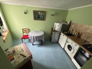 a small kitchen with a table and a washing machine at Borjomi Cozy Cottage in Borjomi
