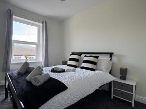 a bedroom with a bed with pillows and a window at Birks Terrace - 2 Bedroom - Sleeps 4 in Cleator Moor